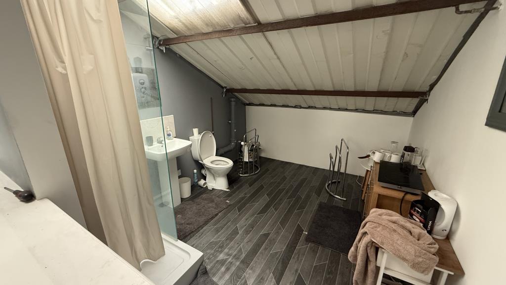 Lot: 57 - FREEHOLD CAR WORKSHOP AND GARAGE - Interior image of mezzanine floor with shower area and WC